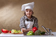 Foto: Little boy with chef hat washing vegetables Little boy with chef hat washing vegetables