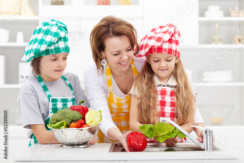 Photo: Woman and kids preparing the vegetables for a meal Woman and kids preparing the vegetables for a meal
