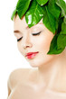 beautiful woman's face, surrounded by green leaves