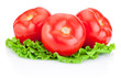Three juicy tomatoes with green leaves lettuce  isolated on whit