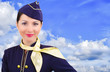 Beautiful smiling stewardess on a background sky