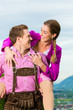 Paar in Tracht auf Wiese vor Bergpanorama