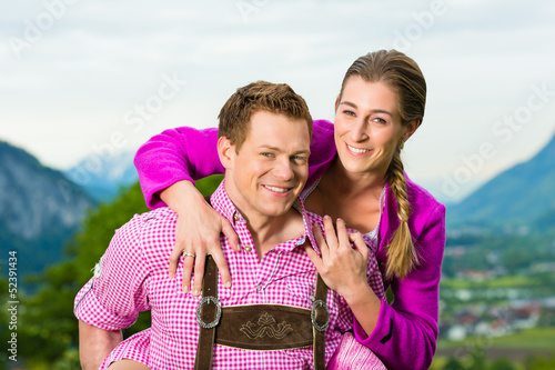 Photo: Paar in Tracht auf Wiese vor Bergpanorama Paar in Tracht auf Wiese vor Bergpanorama