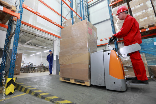 Photo: forklift loader with cardboard freight moving in storehouse forklift loader with cardboard freight moving in storehouse