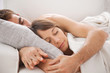 Portrait of a young couple sleeping on bed