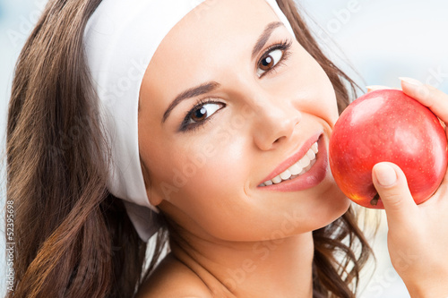 Photo: Woman with apple, at fitness center Woman with apple, at fitness center