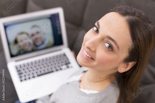 Photo: Portrait of a woman on sofa with her laptop Portrait of a woman on sofa with her laptop