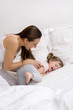 Mother and daughter playing on the bed