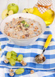 Useful oatmeal in bowl with fruit on wooden table close-up