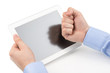Mans hands holding a tablet computer and threatening by a fist a