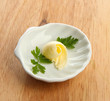 Butter curl on plate, on wooden table