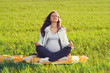 Beautiful pregnant woman relaxing on grass