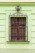 Photo: Window with metal security bars on the green wall of the residen Window with metal security bars on the green wall of the residen