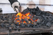 Blacksmith forges a red-hot iron in the forge