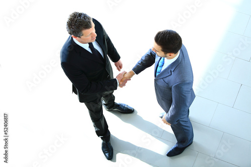 Photo: Top view of a two businessman shaking hands Top view of a two businessman shaking hands