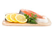 Salmon steaks on cutting board with lemons and herbs