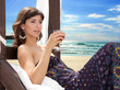 Photo: Young woman with a drink on the beach Young woman with a drink on the beach