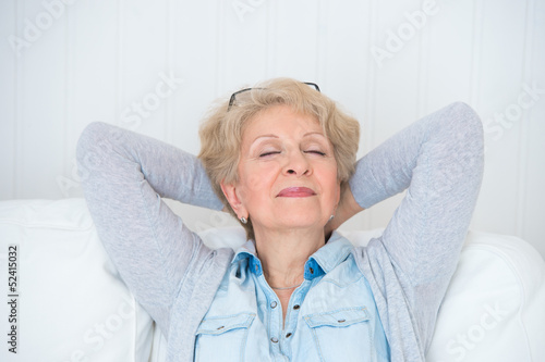 Photo: Smiling happy senior woman relaxing at home Smiling happy senior woman relaxing at home