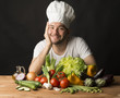cook with vegetables on black background