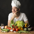 cook with vegetables on black background