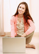 Photo: A young woman with a laptop sitting on the floor A young woman with a laptop sitting on the floor
