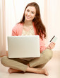 Photo: Young woman sitting on thr floor with laptop Young woman sitting on thr floor with laptop