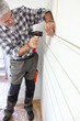 Carpenter nailing panels to house