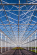 Partly empty greenhouse against a blue sky