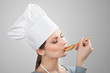 Photo: Woman in chef's hat tasting sauce with a wooden spoon Woman in chef's hat tasting sauce with a wooden spoon