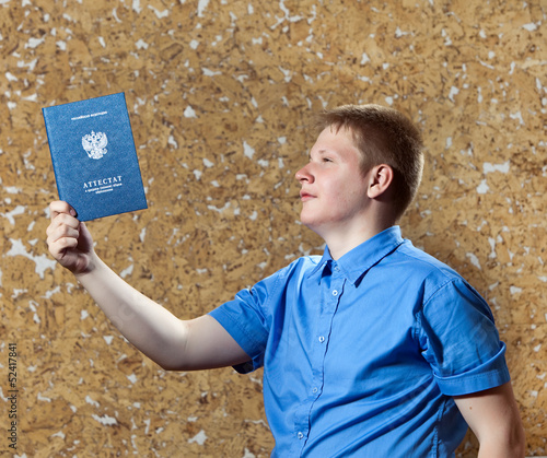 Photo: young man with the certificate of education at school.. young man with the certificate of education at school..