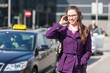 Young Woman Talking on Mobile waiting for Taxi