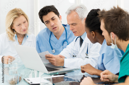Photo: Team Of Doctors Examining Reports Team Of Doctors Examining Reports
