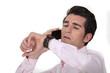 Foto: businessman talking on his cell and looking at his watch businessman talking on his cell and looking at his watch
