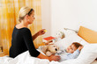 Mutter und krankes Kind im Bett. Grippe.