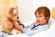 canvas print picture - Krankes Kind untersucht Teddy mit Stethoskop