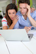 Couple looking at bank account with shocked expression