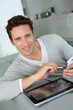 Foto: Man in sofa using tablet and smartphone Man in sofa using tablet and smartphone