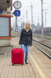 Frau wartet auf Bahnhof auf ihren Zug