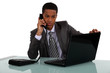 Executive with a phone and laptop