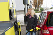 Frau beim tanken auf Tankstelle