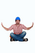 Foto: Surprised laborer sitting on white background Surprised laborer sitting on white background