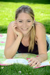 Junge Frau liest Buch in Park