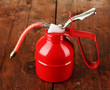 Red oil can, on wooden background