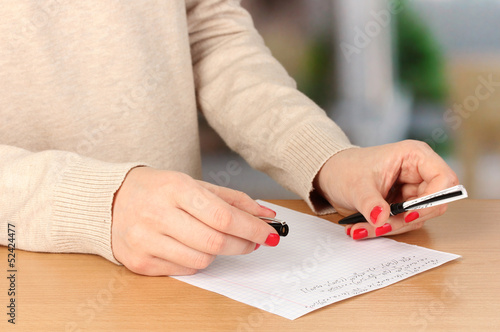 Photo: Write off exam on wooden table on room background Write off exam on wooden table on room background