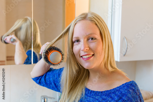 Photo: Frau bürstet sich die Haare Frau bürstet sich die Haare