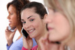 Three female friends on mobile telephones