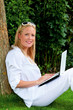 Frau mit Laptop Computer im Garten