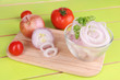 Onion cut with rings in bowl on wooden table close-up