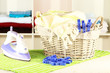 Clothes and iron on table on shelves background