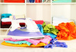 Photo: Clothes and iron on table on shelves background Clothes and iron on table on shelves background